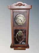 A Continental oak eight day wall clock with silvered dial