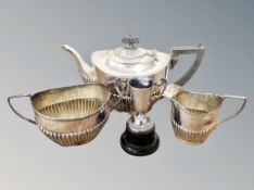 A small silver trophy cup on ebonised stand together with a three piece EPNS tea service