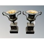 A pair of Victorian gilded spelter urns on black slate stepped bases, height 26 cm.