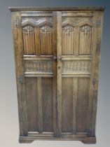 An oak linen fold double door wardrobe,