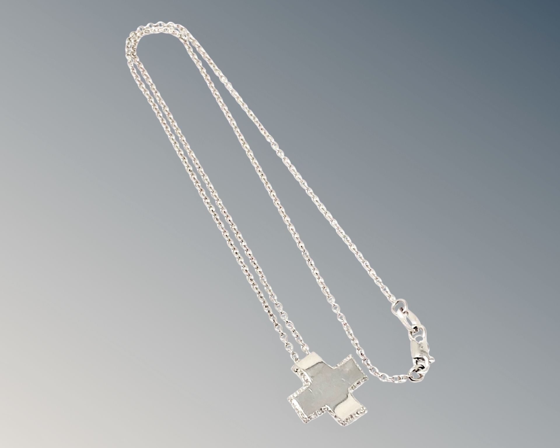 An 18ct white gold diamond set cross pendant on chain CONDITION REPORT: 4.