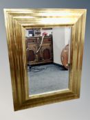 A gilt cushion framed bevelled overmantle mirror 110 cm x 85 cm