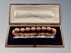 A 14ct yellow gold bracelet set with seventeen oval coral cabochons, 11.1g, length 18.