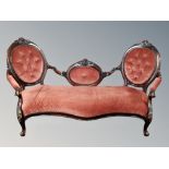 A Victorian carved mahogany salon settee in pink dralon