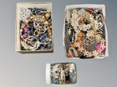 A collection of costume jewellery in two small boxes and a glass jar