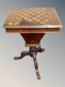 A Victorian inlaid walnut tripod sewing table with chess board top,