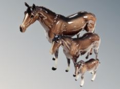 Three Beswick brown gloss horses, largest 36 cm long.