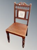 A late Victorian chair with tile inset back rest