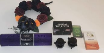 A collection of witchcraft items, wreath, tarot cards, incense smoke box with sticks,