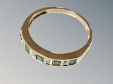 An emerald and diamond half eternity ring