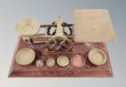 A set of Victorian oak and brass postal scales and a quantity of of weights