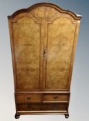 A Queen Anne style burr walnut domed topped wardrobe, fitted drawers beneath,