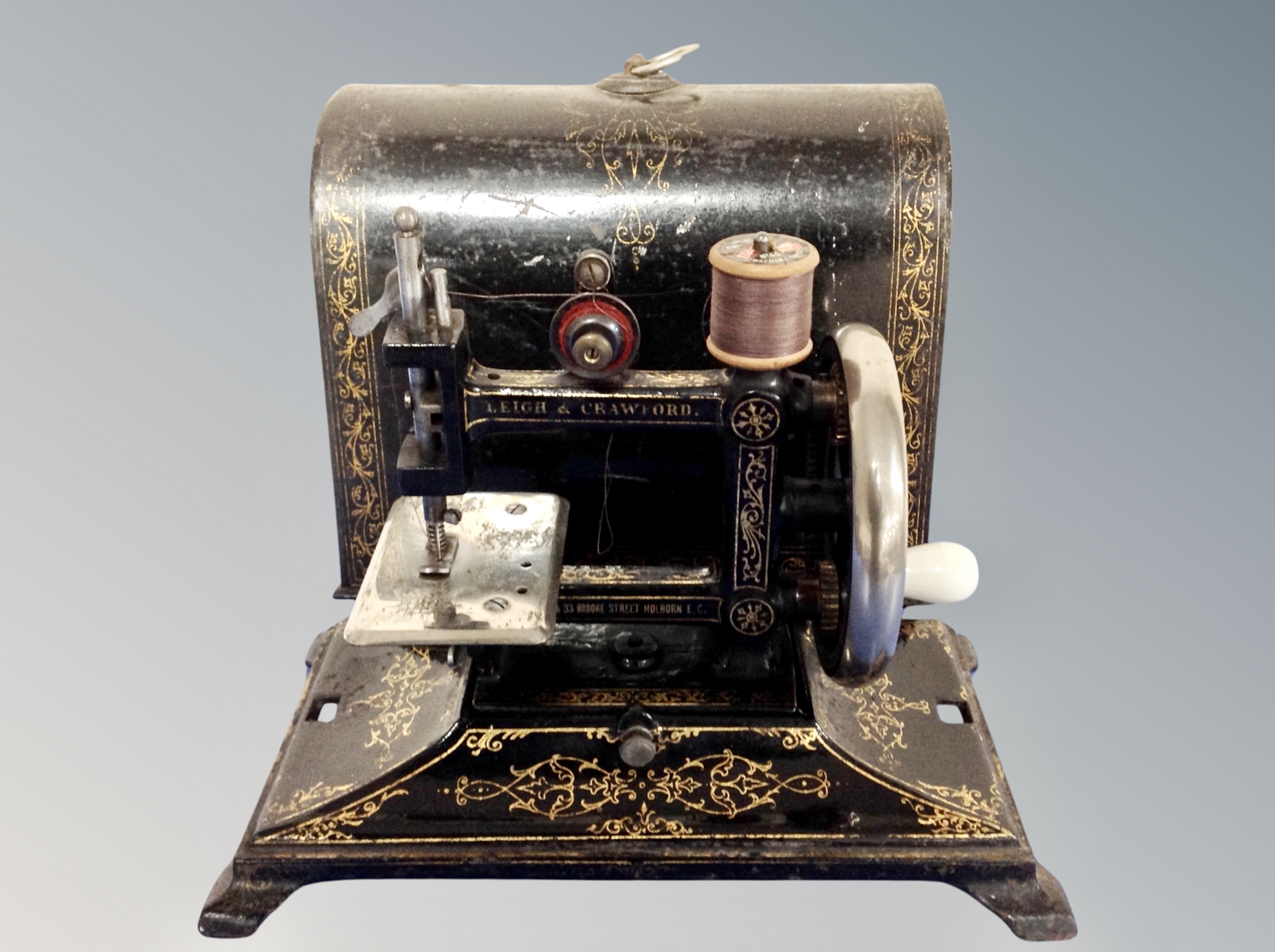 A 19th century Leigh and Crawford child's miniature sewing machine in lacquered box