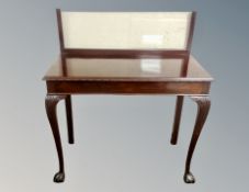An early 20th century mahogany console table with later glass top and glass panel back,
