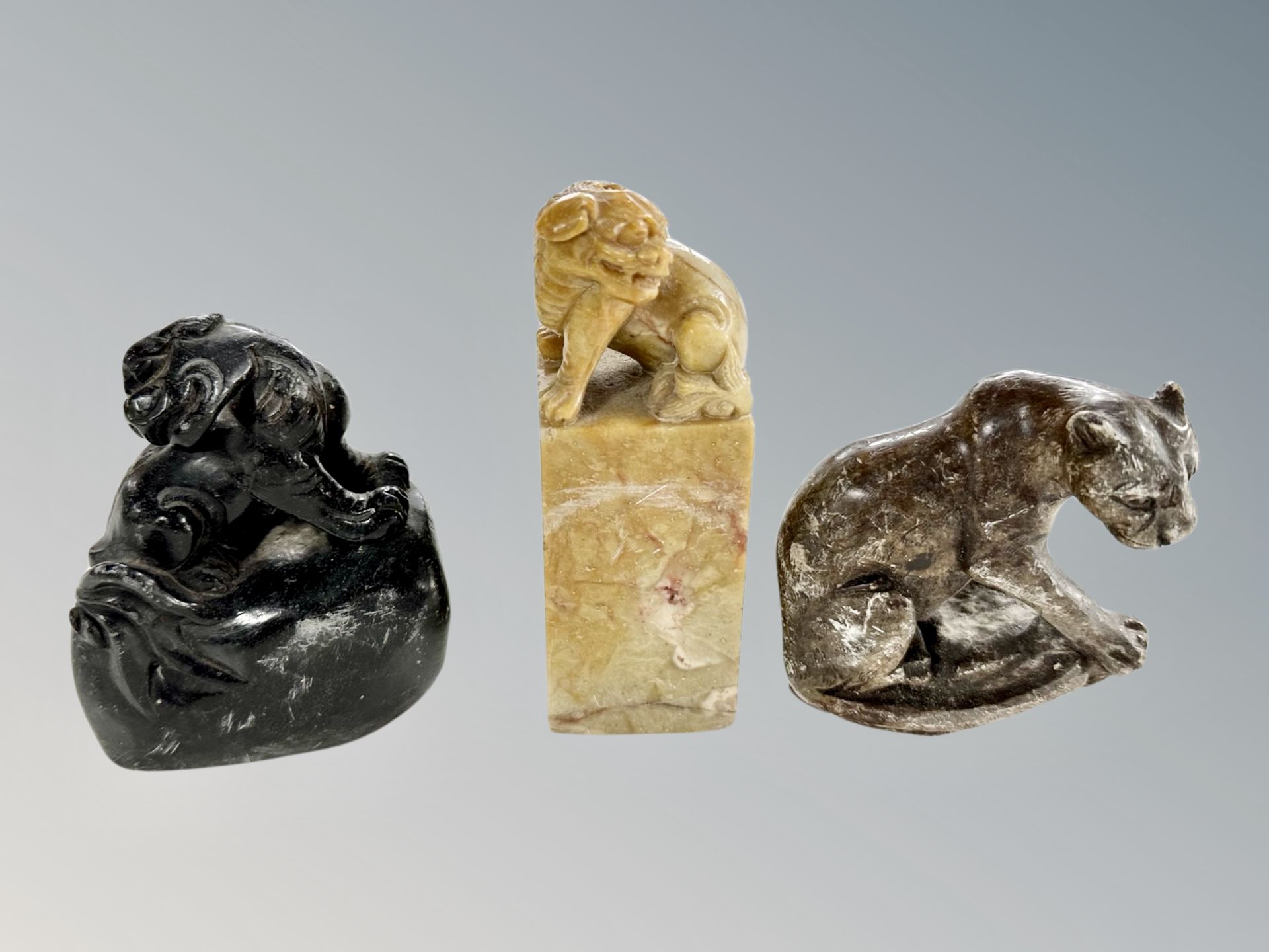 A Chinese carved soapstone scroll weight in the form of a foo dog, height 12 cm,