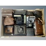 A collection of vintage cameras, two early 20th century bellows cameras, large Polaroid camera,