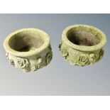 A pair of weathered concrete planters decorated with roses,