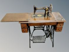 A Singer treadle sewing machine, numbered V1816535, in oak table,