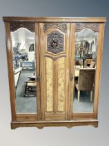 A late Victorian carved walnut triple compactum wardrobe,