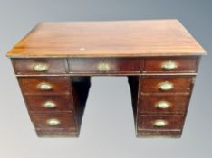 A late Victorian stained pine twin pedestal desk fitted with nine drawers,