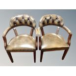 A pair of reproduction mahogany armchairs in deep buttoned chestnut brown leather