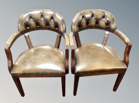 A pair of reproduction mahogany armchairs in deep buttoned chestnut brown leather
