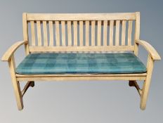 A teak garden bench with cushion,