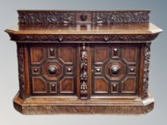 A 19th century continental heavily carved oak sideboard fitted with cupboards,