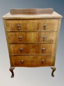 A 1920's figured walnut four drawer chest on cabriole legs,