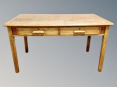 A 1930's oak two drawer writing table,