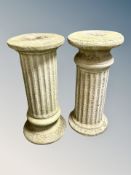 A near pair of weathered concrete classical style pedestals,