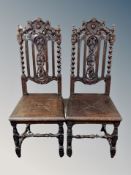 A pair of 19th century heavily carved oak hall chairs