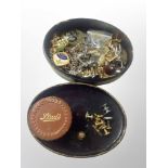 An oval lacquered box of assorted cufflinks, tie pins,