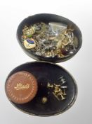 An oval lacquered box of assorted cufflinks, tie pins,