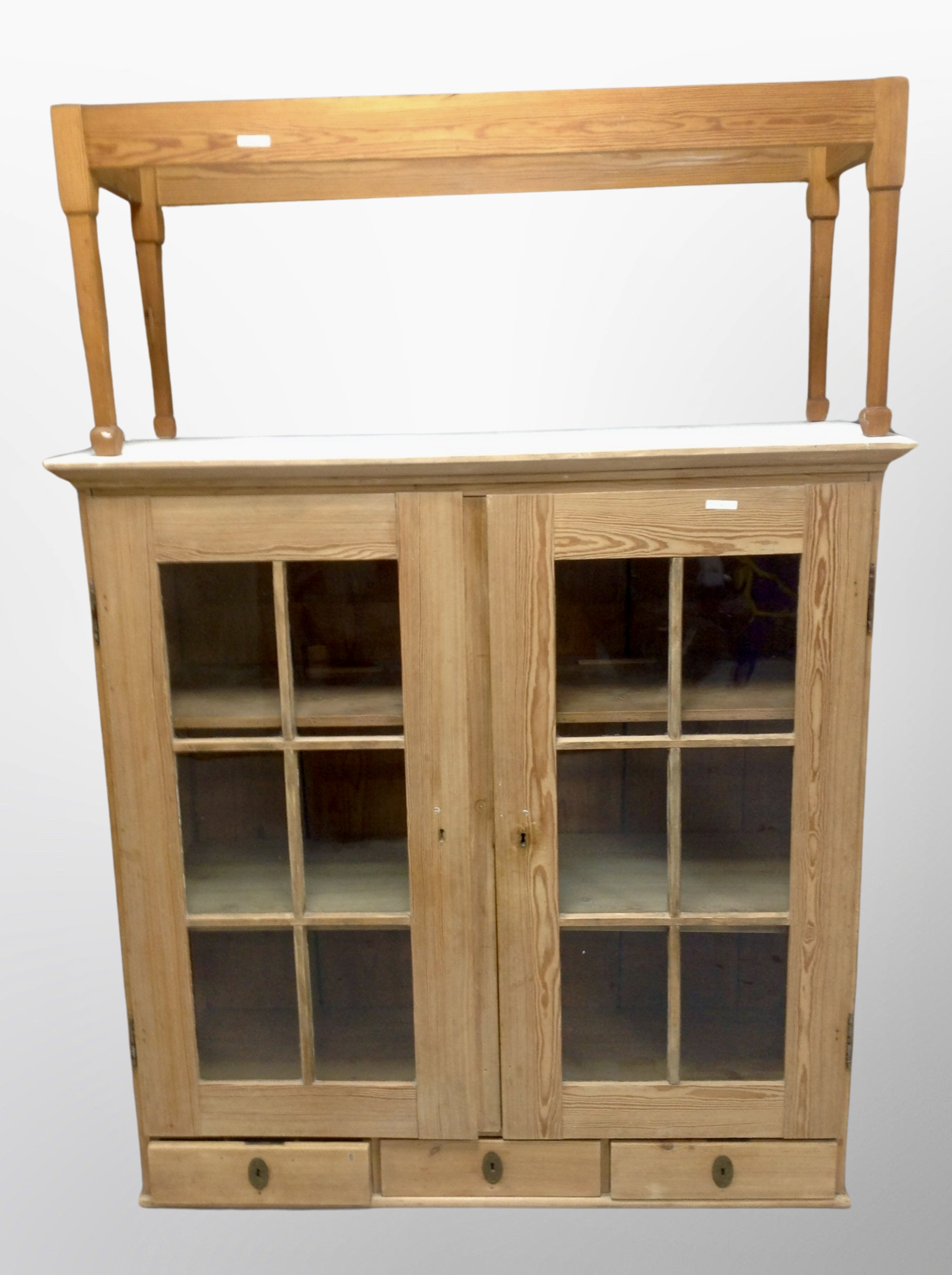 A 19th century stripped pine glazed bookcase and a further pine table base