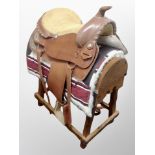 A Western Saddle on wooden saddle stand