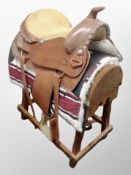 A Western Saddle on wooden saddle stand