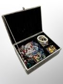A mirrored jewellery box containing costume jewellery, bead necklaces,