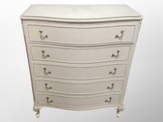 A cream and gilt five drawer serpentine fronted chest,