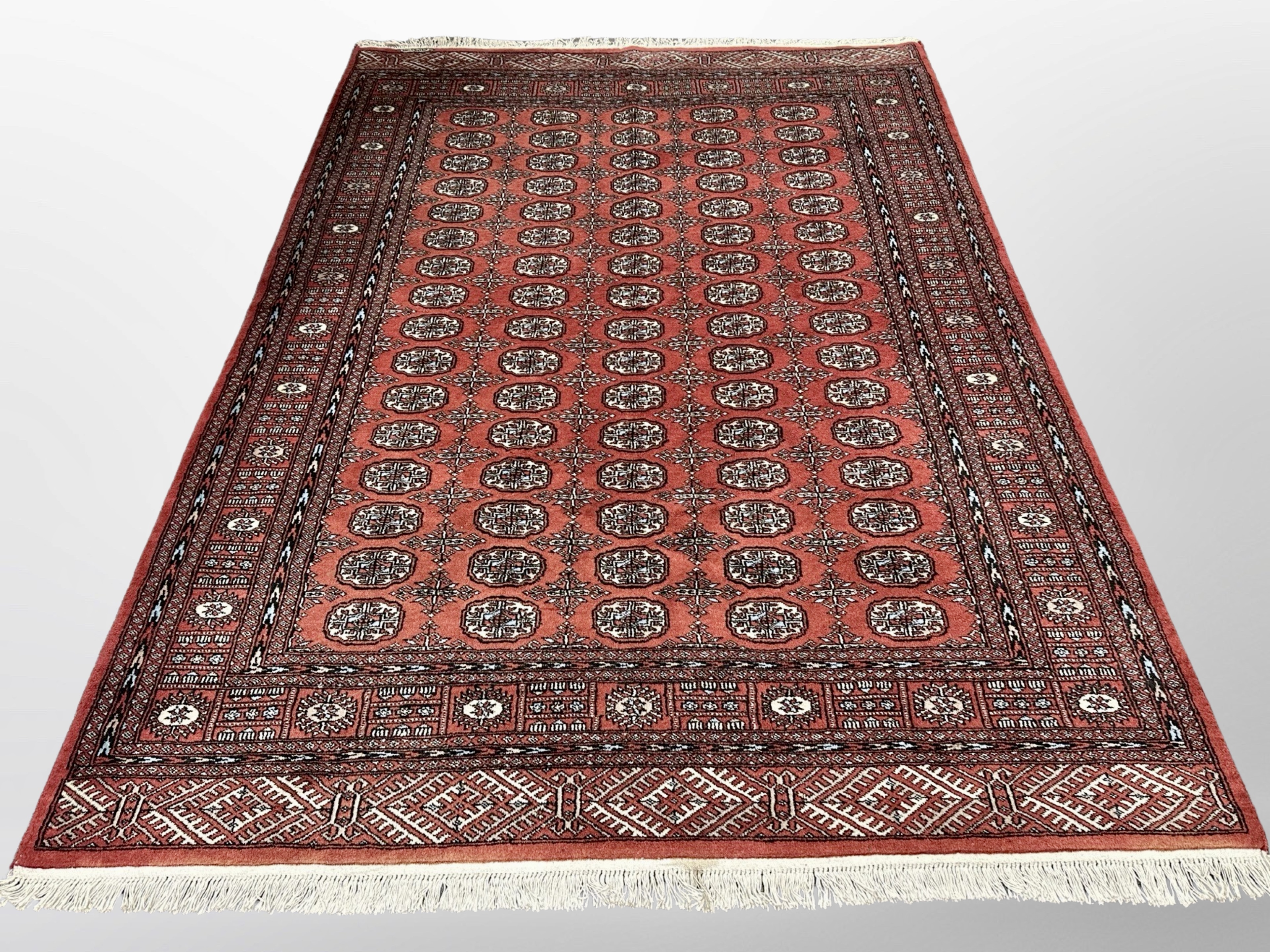 A Lahore Bokhara rug on red ground 253 cm x 171 cm