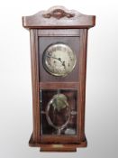 A Continental oak eight day wall clock with silvered dial