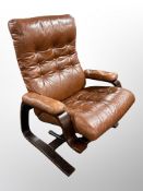 A 20th century Danish stained beech and buttoned tan leather manual reclining armchair
