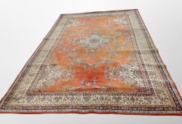 A machine made carpet of Persian design on red ground 454 cm x 274 cm