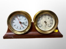 A brass cased quartz timepiece and pressure gauge mounted on mahogany plinth,
