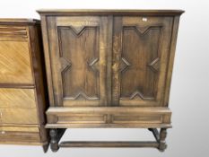 An early 20th century Danish panelled oak double door cabinet on stand,