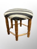 A hexagonal footstool in striped upholstery