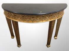 A period-style demi-lune console table with black granite top,