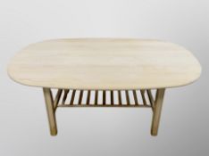 A Danish stripped pine oval coffee table with undershelf,