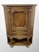 A Danish carved oak corner cabinet fitted a cupboard and drawers,