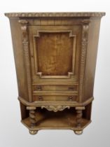 A Danish carved oak corner cabinet fitted a cupboard and drawers,
